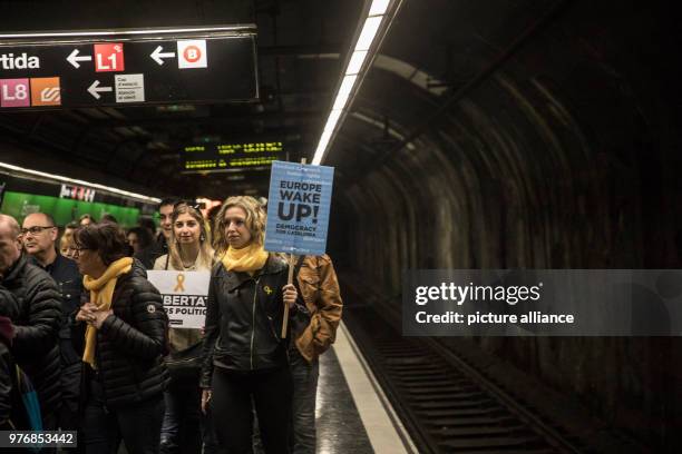 April 2018, Spain, Barcelona: A protestor carries a sign reading 'Europa, wach auf! Demokratie für Katalonien' on her way to a rally supporting...