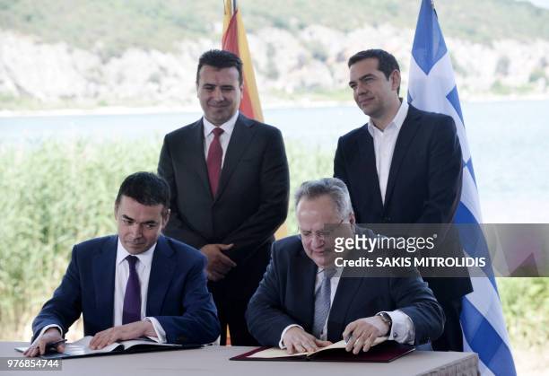 Greek Foreign Minister Nikos Kotzias and his Macedonian counterpart Nikola Dimitrov sign a preliminary accord as Greek Prime Minister Alexis Tsipras...