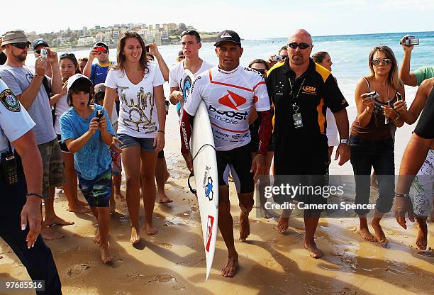 Kelly Slater of the United States is escorted up the beach following a heat of the Boost Bondi Beach SurfSho at Bondi Beach on March 14, 2010 in...