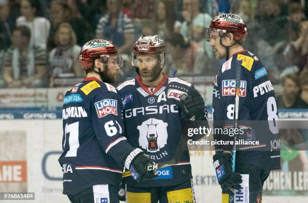 April 2018, Germany, Berlin: Ice hockey DEL, Eisbaeren Berlin vs EHC Red Bull Muenchen at the Mercedes-Benz Arena: Berlin's Sean Backman , Louis Marc...