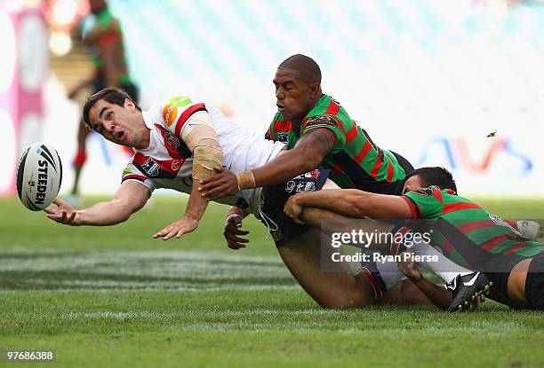 Aidan Guerra of the Roosters passes the ball as Eddy Pettybourne of the Rabbitohs during the round one NRL match between the South Sydney Rabbitohs...