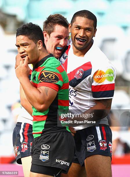 Mitchell Pearce and Frank-Paul Nuuausala of the Roosters celebrate a try as Issac Luke of the Rabbitohs looks dejected during the round one NRL match...