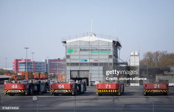 April 2018, Germany, Hamburg: Automatic container transporters outside a building with a battery changing station at the Container Terminal...