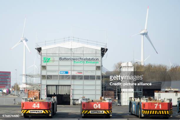 April 2018, Germany, Hamburg: Automatic container transporters outside a building with a battery changing station at the Container Terminal...