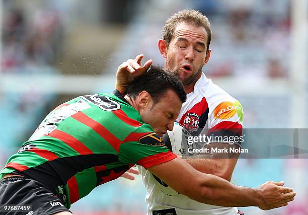 Phil Graham of the Roosters is tackled by Beau Champion of the Rabbitohs during the round one NRL match between the South Sydney Rabbitohs and the...