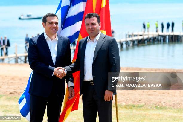 Macedonian Prime Minister Zoran Zaev welcomes Greek Prime Minister Alexis Tsipras on the shore of the Lake Prespa near Otesevo on June 17, 2018. -...