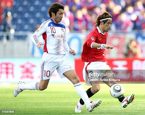 Hajime Hosogai of Urawa Red Diamonds and Yohei Kajiyama of F.C. Tokyo compete for the ball during the J.League match between Urawa Red Diamonds and...