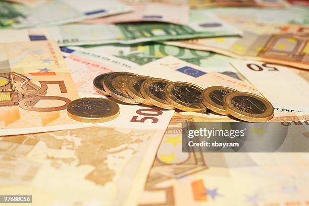 introducción de las monedas y de los billetes. - fajo de billetes de euro fotografías e imágenes de stock