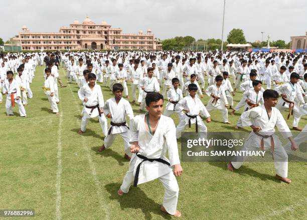 Indian students participate in a mass 'Kata' marking the International World Karate Day at the SGVP Gurukul on the outskirts of Ahmedabad on June 17,...