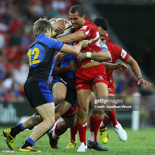 Quade Cooper of the Reds is tackled during the round five Super 14 match between the Reds and the Western Force at Suncorp Stadium on March 14, 2010...