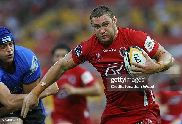 Scott Higginbotham of the Reds breaks through a tackle from Nathan Sharpe of the Force during the round five Super 14 match between the Reds and the...