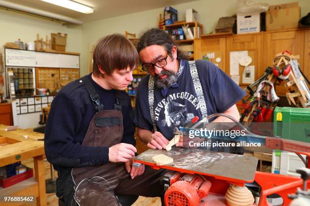 April 2018, Germany, Nuremberg: Philipp , a youth with Down's syndrome, speaks with the security officer of the wood workshop Olivier-Jean Feit at...