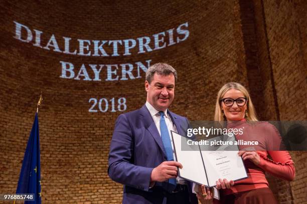 April 2018, Germany, Munich: Markus Soeder of the Christian Democratic Union , Premier of Bavaria, standing onstage with Monika Gruber, cabaret...