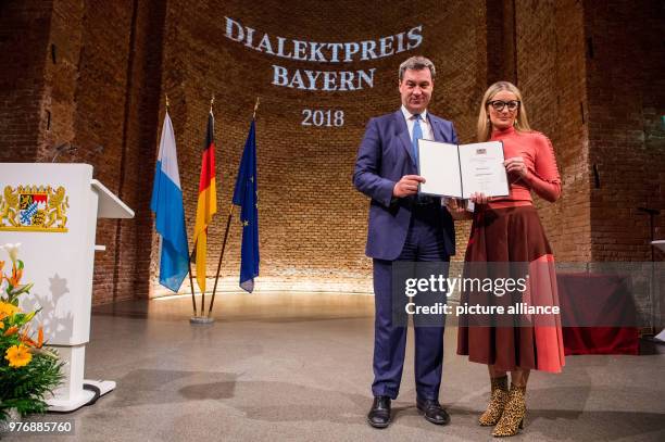 April 2018, Germany, Munich: Markus Soeder of the Christian Democratic Union , Premier of Bavaria, standing onstage with Monika Gruber, cabaret...