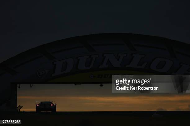 The MR Racing Ferrari 488 GTE of Motoaki Ishikawa, Olivier Beretta and Eddie Cheever drives under the iconic Dunlop Bridge at dawn during the Le Mans...