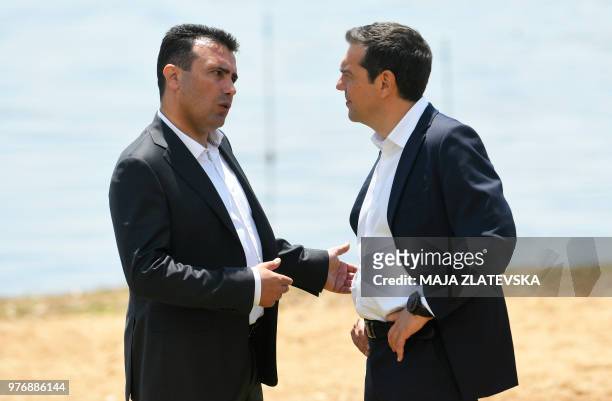 Macedonian Prime Minister Zoran Zaev welcomes Greek Prime Minister Alexis Tsipras on the shore of the Lake Prespa near Otesevo on June 17, 2018. -...