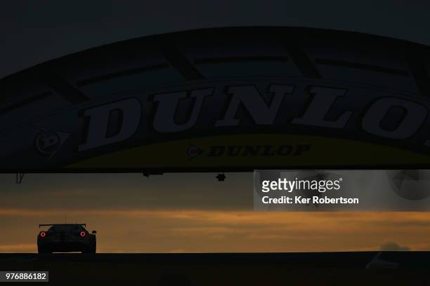 The MR Racing Ferrari 488 GTE of Motoaki Ishikawa, Olivier Beretta and Eddie Cheever drives under the Dunlop Bridge at dawn during the Le Mans 24...