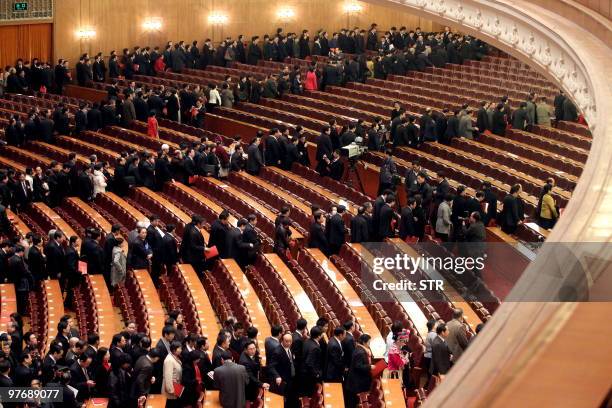 Delegates queue to leave the Great Hall of the People leaves after the closing session of the annual National People's Congress in Beijing on March...