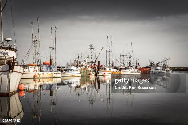 steveston fishing boats moored at marina dark - bc commercial fishing boats stock pictures, royalty-free photos & images