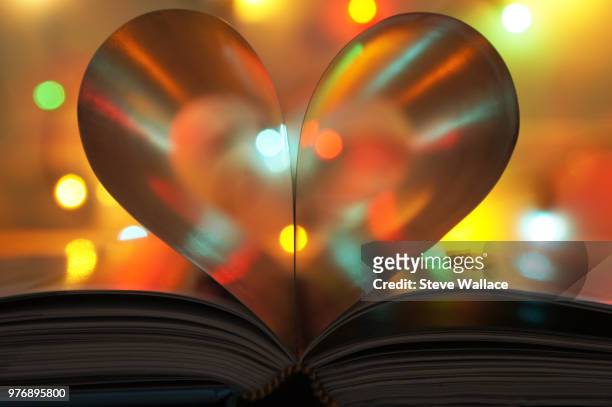 illuminated book with pages forming heart - love books stock-fotos und bilder