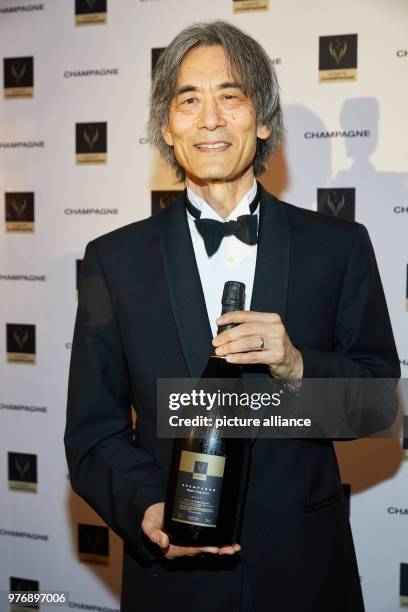 April 2018, Hamburg, Germany: The award winner Kent Nagano holding a bottle of champagne at the Hotel Louis C. Jacob in Hamburg-Nienstedten during...