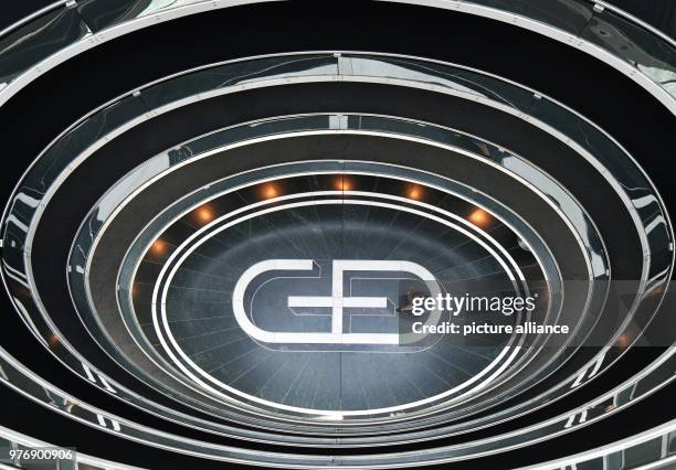 April 2018, Bavaria, Germany: A woman walks across a floor depicting the logo of the company Giesecke & Devrient , which provides banknote and...