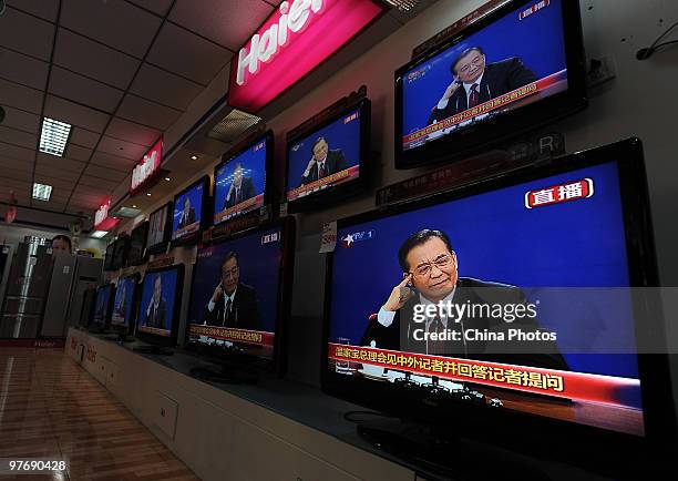 Televisions in a shop show the live broadcast of Chinese Premier Wen Jiabao's press conference after the closing of the National People's Congress on...