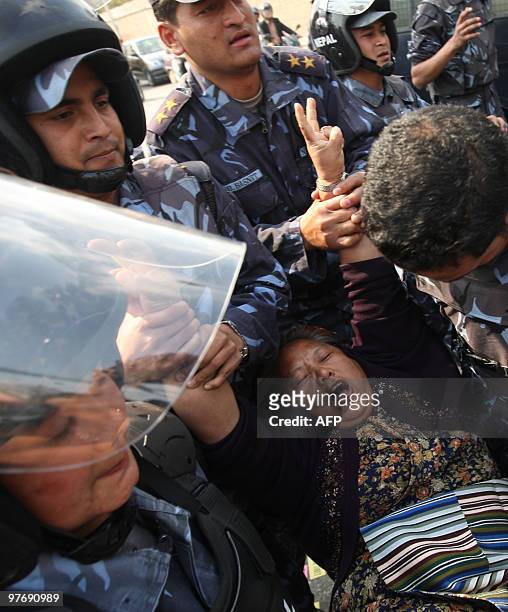 Nepalese riot police arrest a Tibetan protester in front of the consular section of the Chinese Embassy in Kathmandu on March 14 during a protest to...