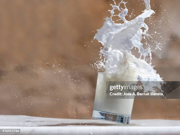 impact of a glass of crystal with milk that falls down on the soil. - crystal glasses stockfoto's en -beelden