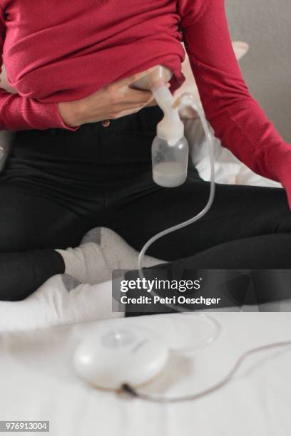 a young mother expressing breast milk with a breast pump. - pump schoen stock-fotos und bilder