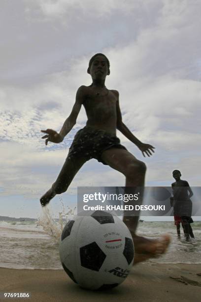 An Angolan boy plays football on the Atlantic ocean beach in Benguela on January 29, 2010 during the African Nations Cup football tournament which...