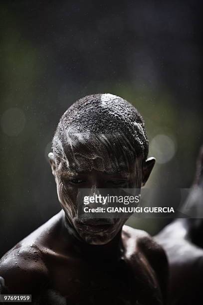 An Angolan boy is covered in soap at the "Cascada de Huila" a natural waterfall on the outskirt of Lubango on January 23, 2010. Lubango will host one...