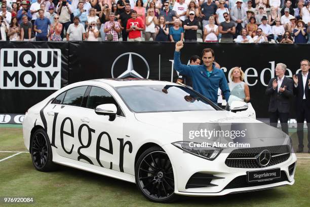 Roger Federer of Switzerland poses with his new Mercedes-Benz CLS 450 4MATIC Coupe after defeating Milos Raonic of Canada in the final match on day 7...