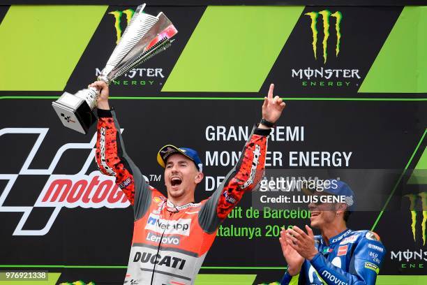 Ducati Team's Spanish rider Jorge Lorenzo celebrates on the podium next to Movistar Yamaha MotoGP's Italian rider Valentino Rossi after winning the...