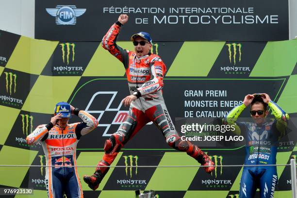 Ducati Team's Spanish rider Jorge Lorenzo , first placed, celebrates next to Repsol Honda Team's Spanish rider Marc Marquez , second placed, and...