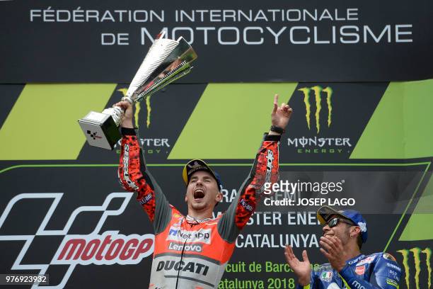 Ducati Team's Spanish rider Jorge Lorenzo , first placed, celebrates next to Movistar Yamaha MotoGP's Italian rider Valentino Rossi , third place, on...