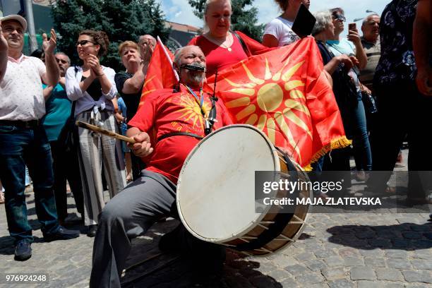 Protesters wave flags and shout slogans during an protest in Bitola on June 17, 2018. - Demonstrators protested against a compromise solution in...