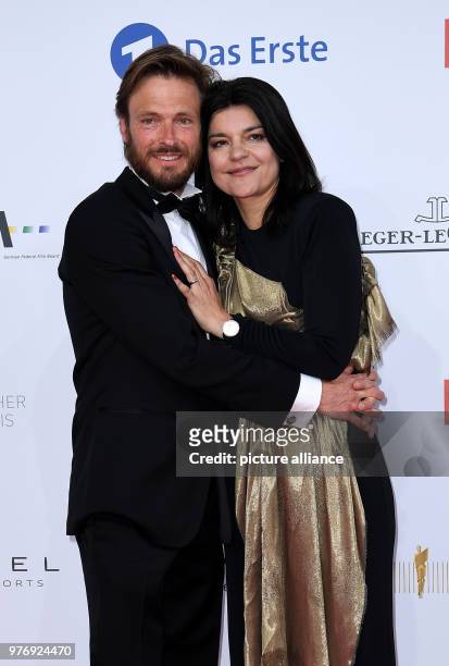 April 2018, Germany, Berlin: Actress Jasmin Tabatabai with her husband Andreas Pietschmann arriving at the 68th award ceremony of the German film...