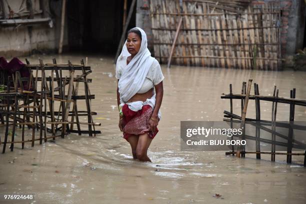 An Indian woman wades through flood water after heavy downpour at Kampur area in Hojai district, some 150 km from Guwahati, the capital city of...