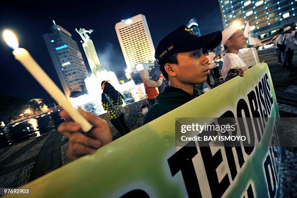 Indonesian Muslims hold candles during a rally for peace in Jakarta on March 14, 2010 to condemn terrorism acts in the world's most populous...