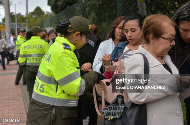 Policewoman checks a voter's bag during the presidential runoff election in Colombia on June 17, 2018 in Bogota. - Colombians choose a new president...