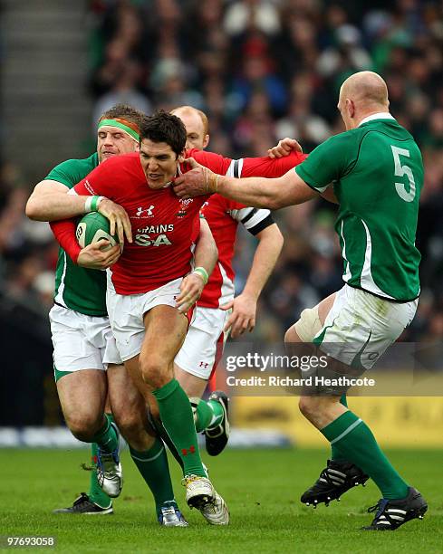 James Hook of Wales is tackled by Jamie Heaslip and Paul O'Connell of Ireland during the RBS Six Nations match between Ireland and Wales at Croke...