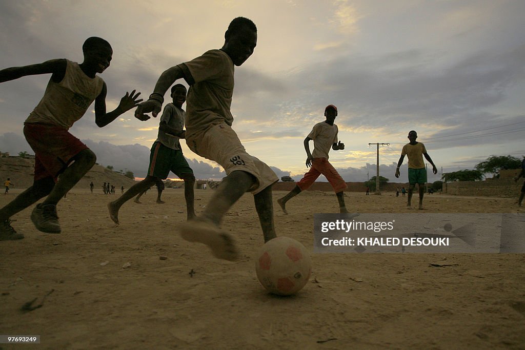 Angolan boys play football outside the S