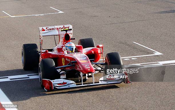 Ferrari's Spanish driver Fernando Alonso celebrates as he crosses the finish line of the Bahrain international circuit on March 14, 2010 in Manama,...