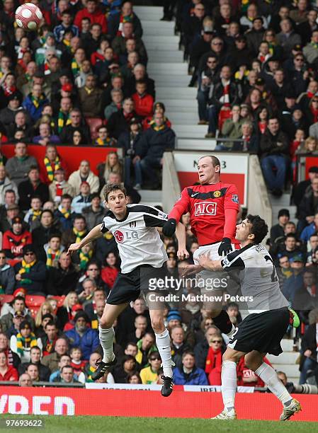 Wayne Rooney of Manchester United clashes with Zoltan Gera and Stephen Kelly of Fulham during the FA Barclays Premier League match between Manchester...
