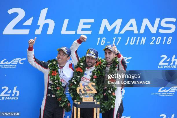 Toyota TS050 Hybrid LMP1's drivers Spain's Fernando Alonso , Japan's Kazuki Nakajima and Switzerland's Sebastien Buemi celebrate on the podium after...