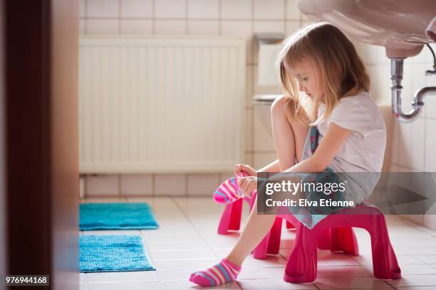 girl (4-5) putting socks on independently - bathmat stock pictures, royalty-free photos & images