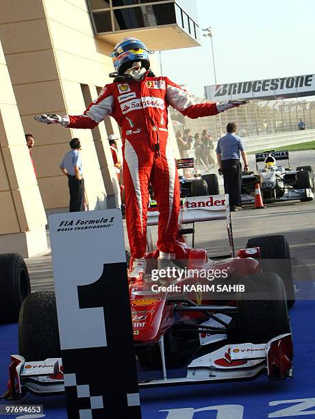 Ferrari's Spanish driver Fernando Alonso celebrates in the parc ferme of the Bahrain international circuit on March 14, 2010 in Manama, after the...