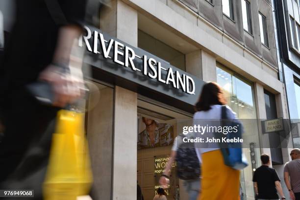 Shoppers walk past the River Island fashion retail shop entrance on Oxford Street on June 11, 2018 in London, England.