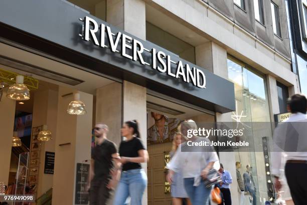 Shoppers walk past the River Island fashion retail shop entrance on Oxford Street on June 11, 2018 in London, England.